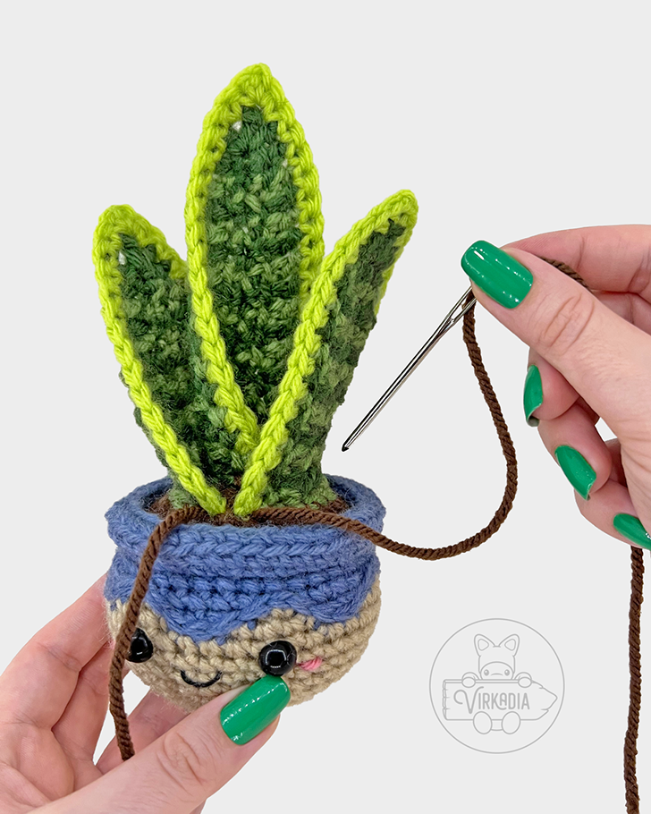 crochet snake plant amigurumi pattern tutorial of how to sew the medium leaves onto the pot dirt