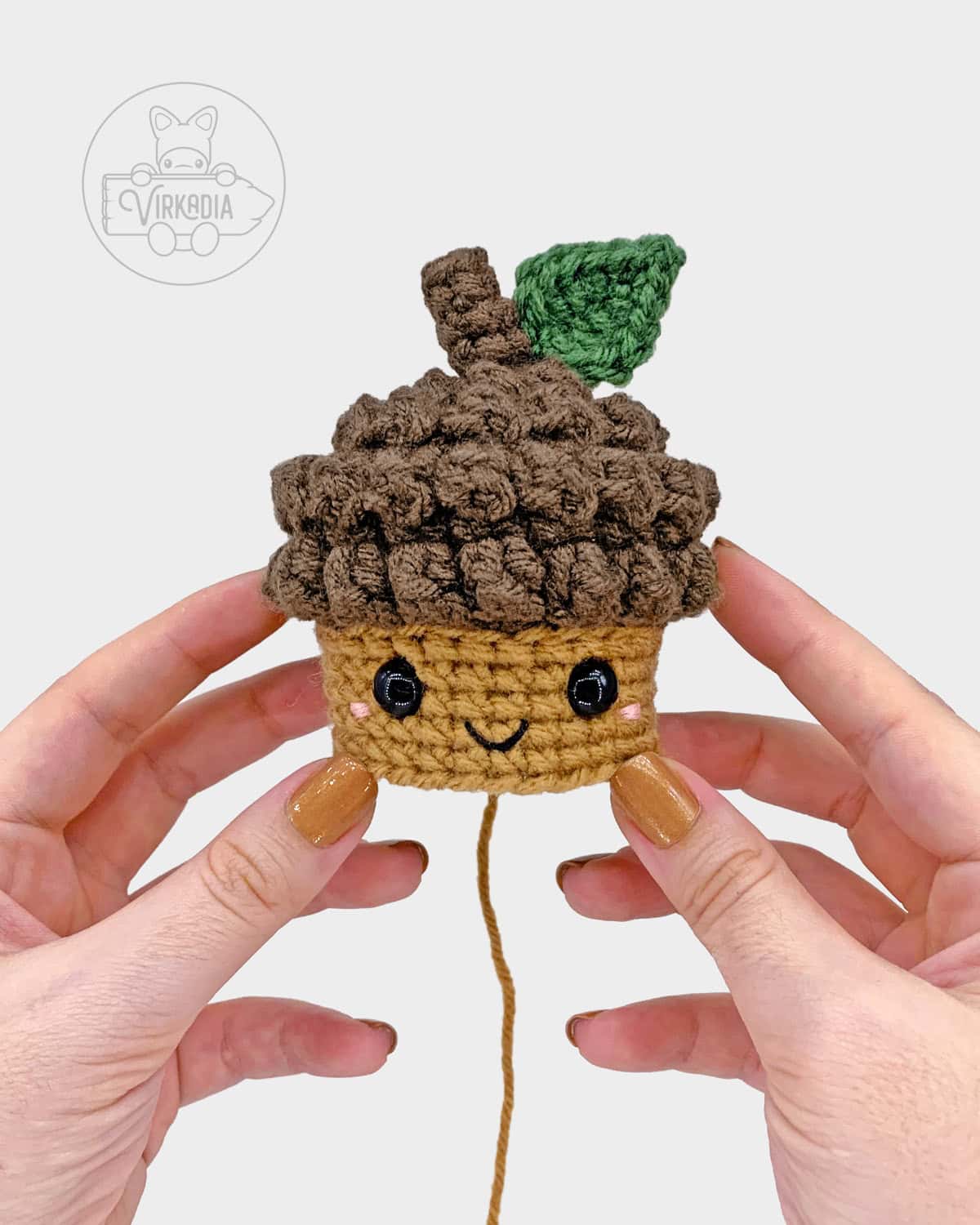 free crochet acorn amigurumi pattern tutorial of where to embroider the face on the nut