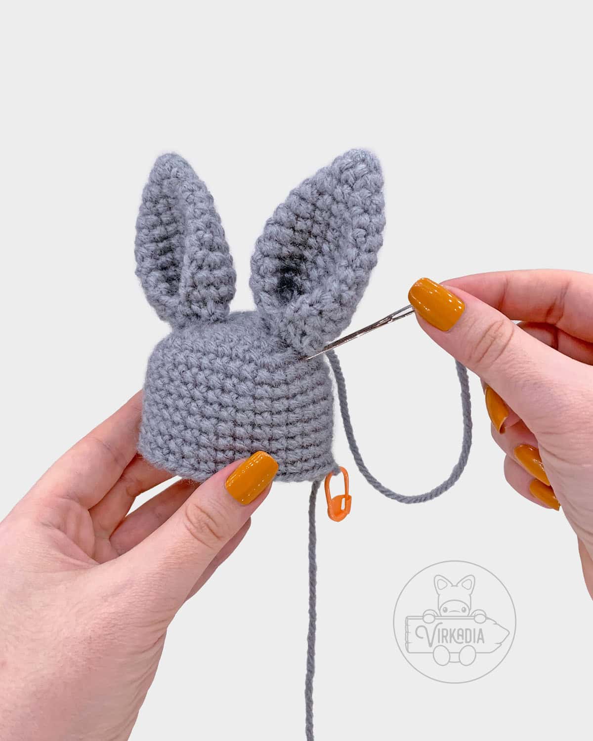 free crochet bunny amigurumi pattern tutorial of how to sew the ears onto the head