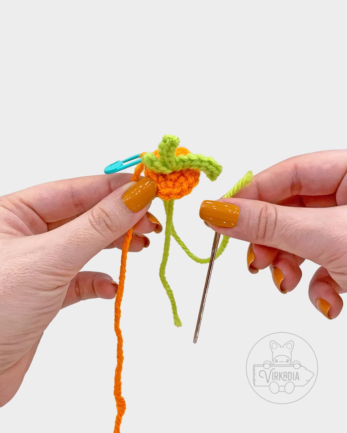 free amigurumi pattern tutorial of how to sew the leaves onto the carrot