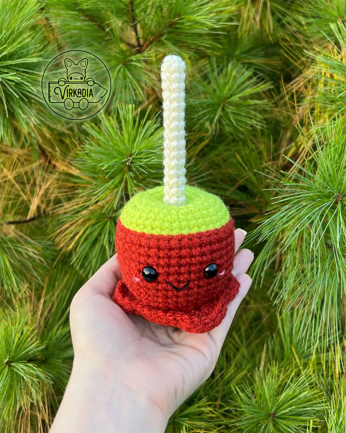candid shot of free crochet candy apple amigurumi plushie for Halloween decorations, spooky food decor, and fall crafts, and DIY gifts