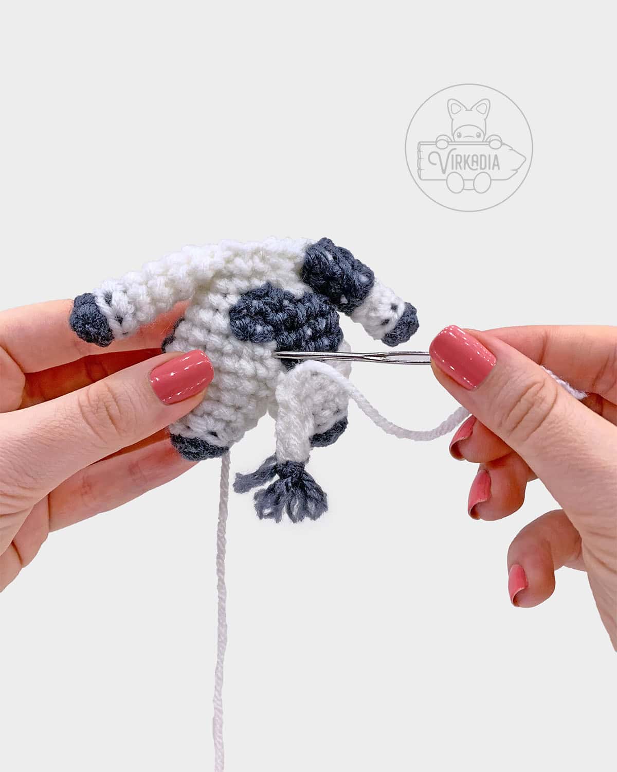 free crochet cow amigurumi pattern tutorial of how to sew the tail onto the body