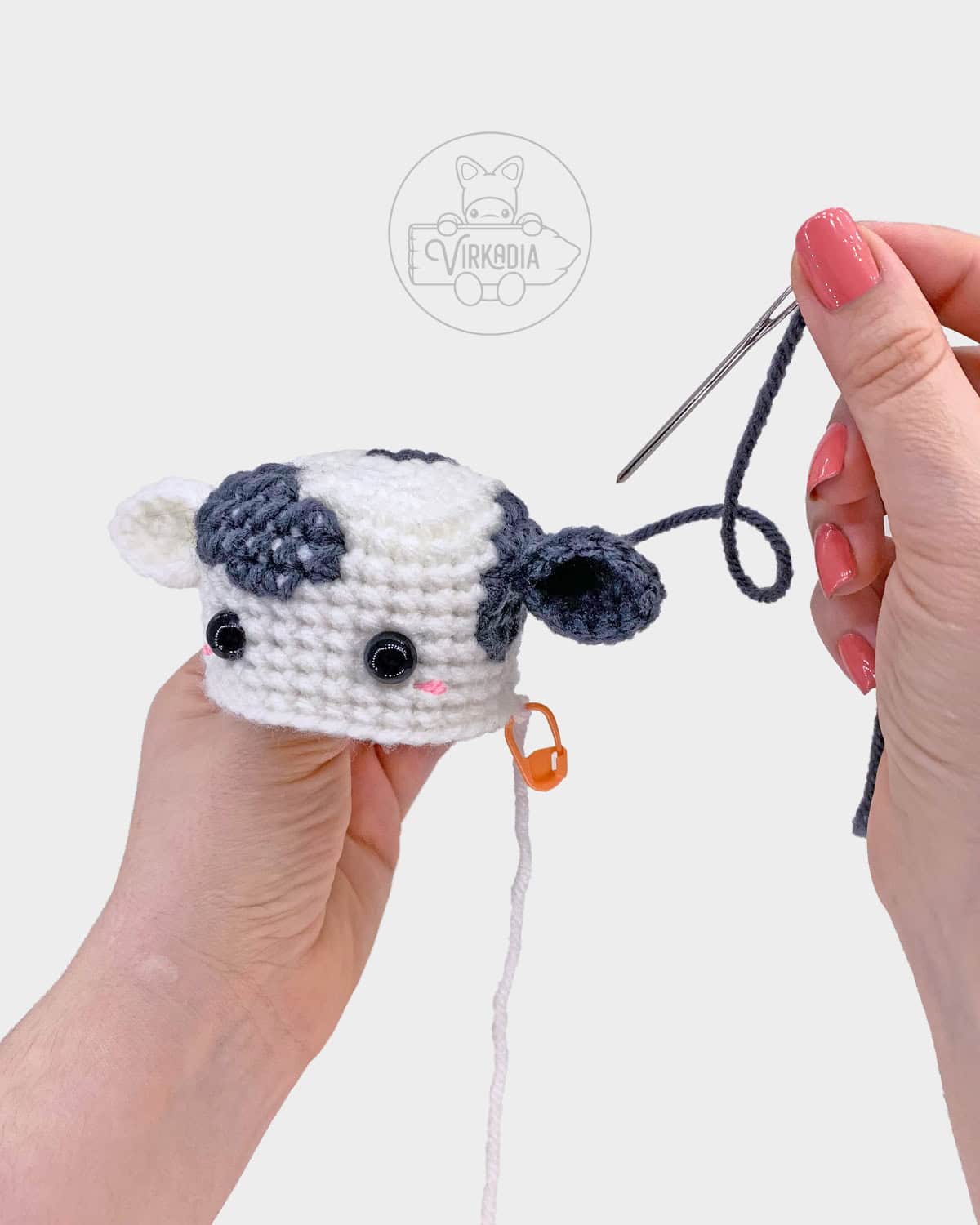 free crochet cow amigurumi pattern tutorial of how to sew the ears onto the head