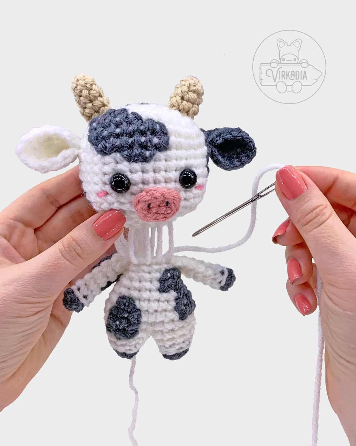 free crochet cow amigurumi pattern tutorial of how to sew the head onto the body