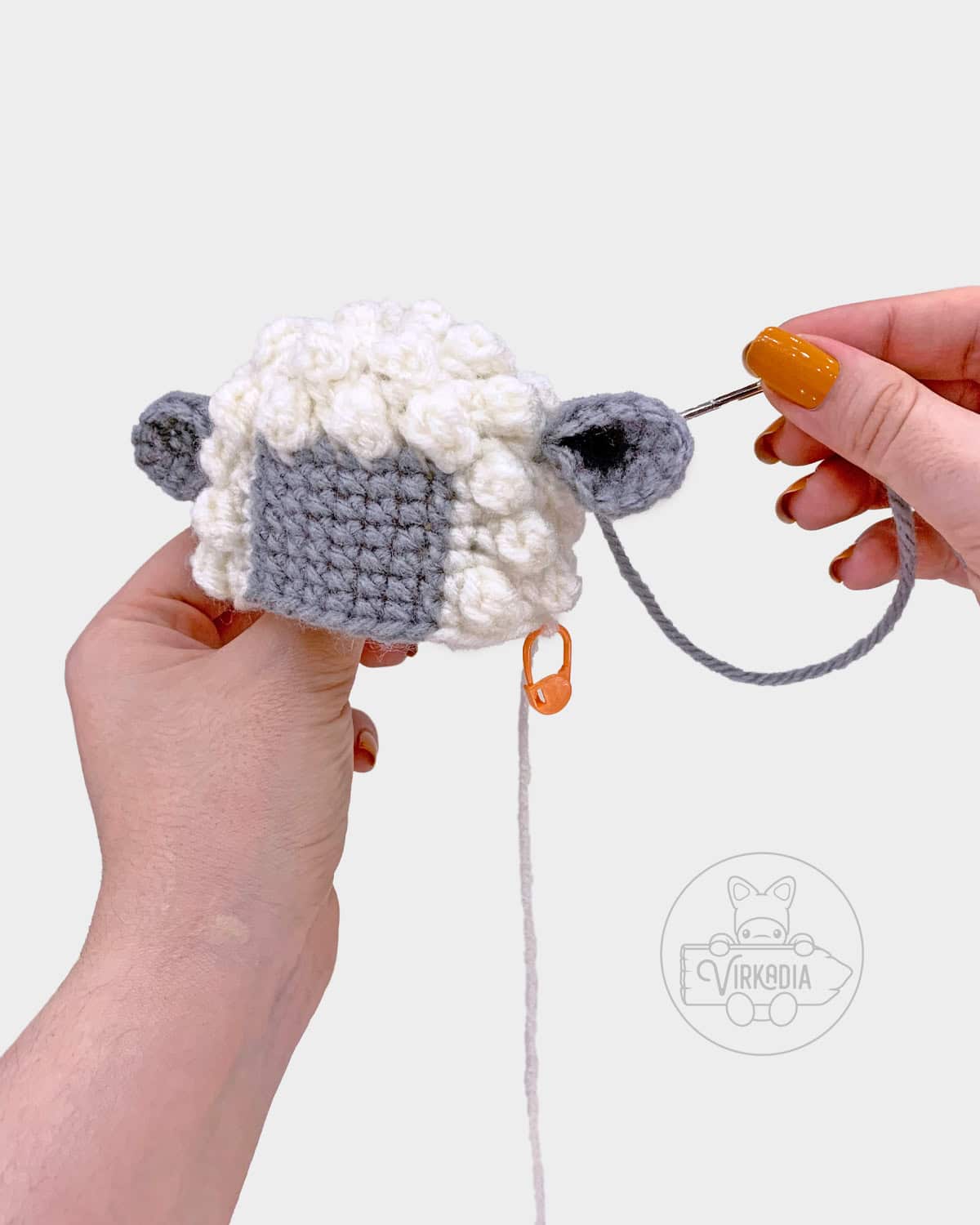 free crochet lamb amigurumi pattern tutorial of how to sew the ears onto the head