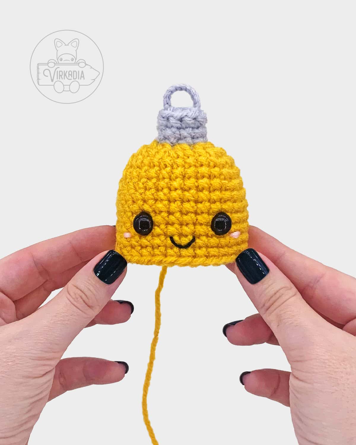 free crochet ornament amigurumi pattern tutorial of where to embroider the face onto the bauble