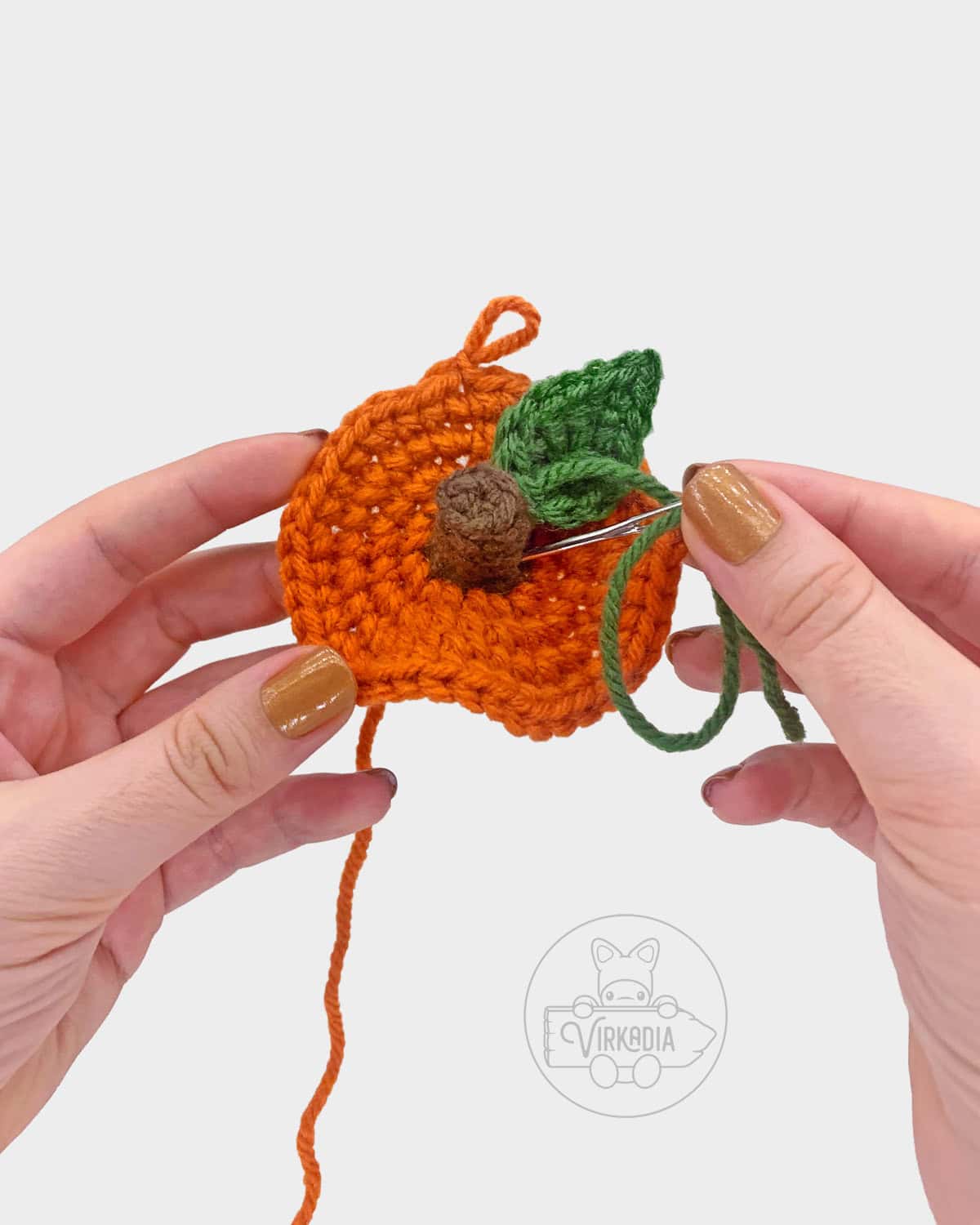 free crochet pumpkin amigurumi pattern tutorial of how to sew the leaf onto the stem