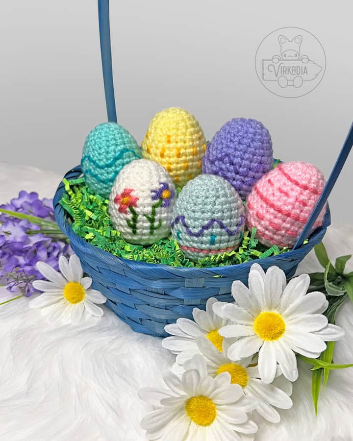 free crochet easter eggs pattern, arranged in an Easter basket, including six different embroidered styles with stripes, spots, waves, zig-zags, and cross stitch flowers for DIY Easter home decor, DIY gifts for Easter baskets, and spring decorations