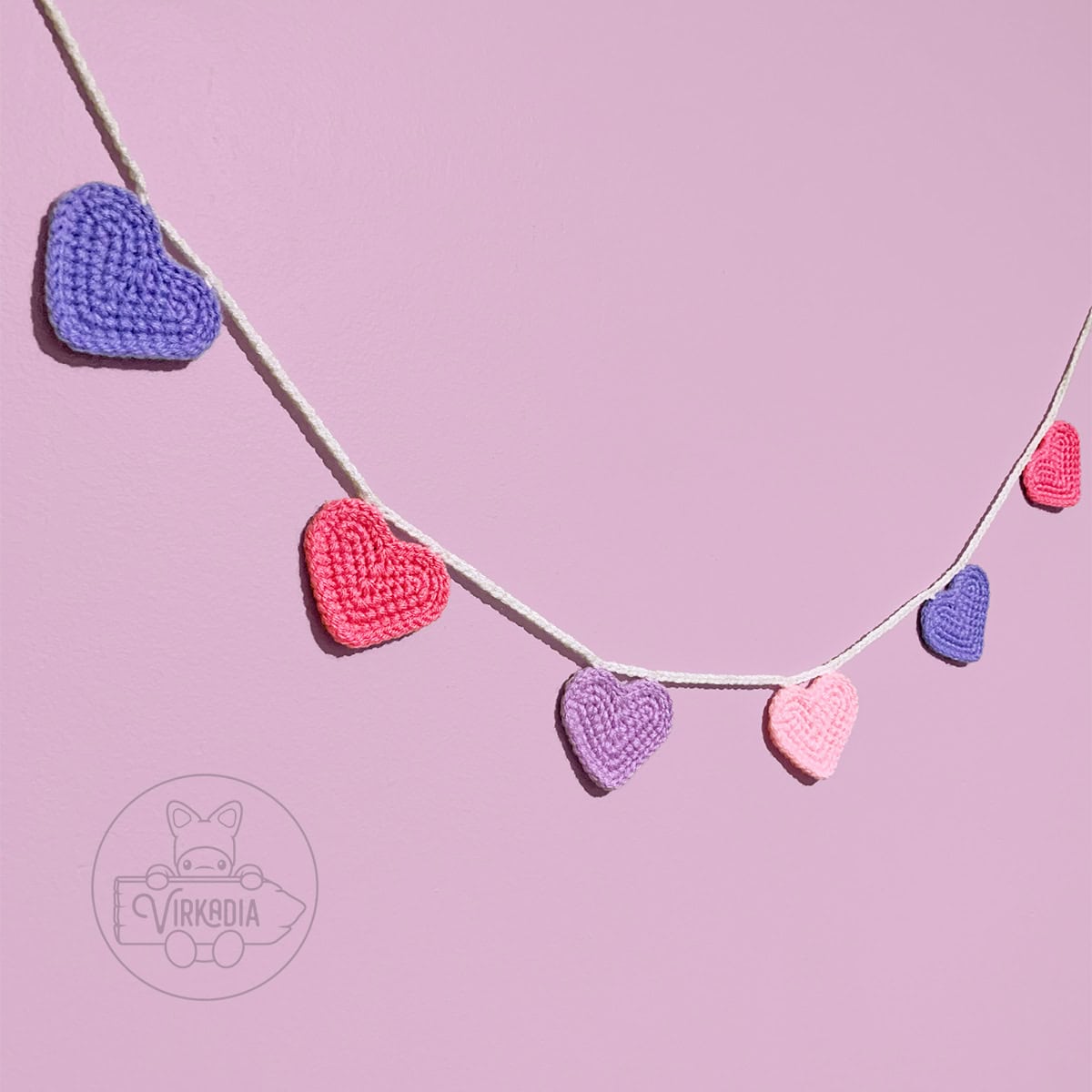 free crochet heart garland pattern strung up for Valentine's Day decorations, romantic crafts, holiday decor, and DIY anniversary gifts