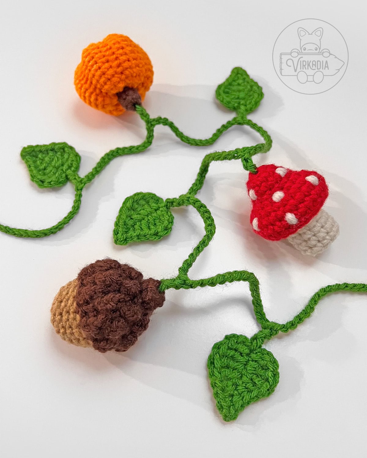 free mini crochet autumn garland with a mushroom, pumpkin, acorn, and leaf motifs for DIY gifts, fall crafts, and homemade autumn decor