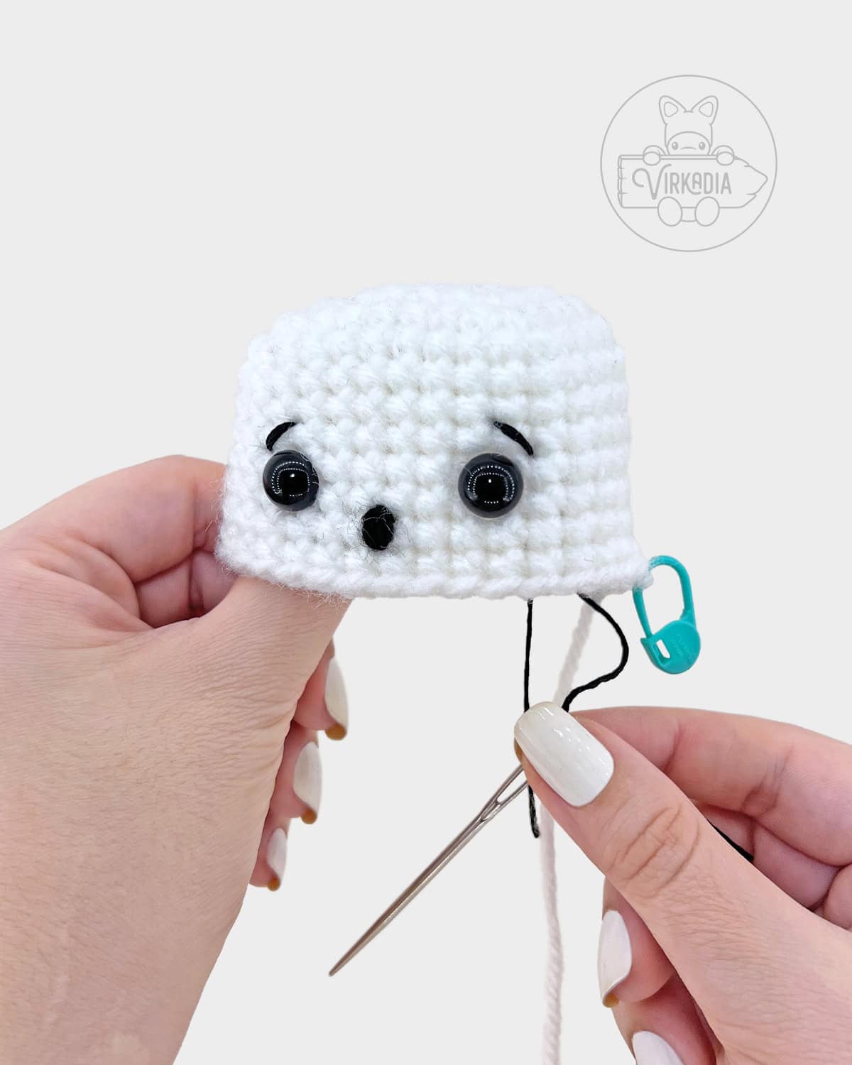 crochet sheet ghost amigurumi pattern tutorial of how to embroider the eyebrows onto the face
