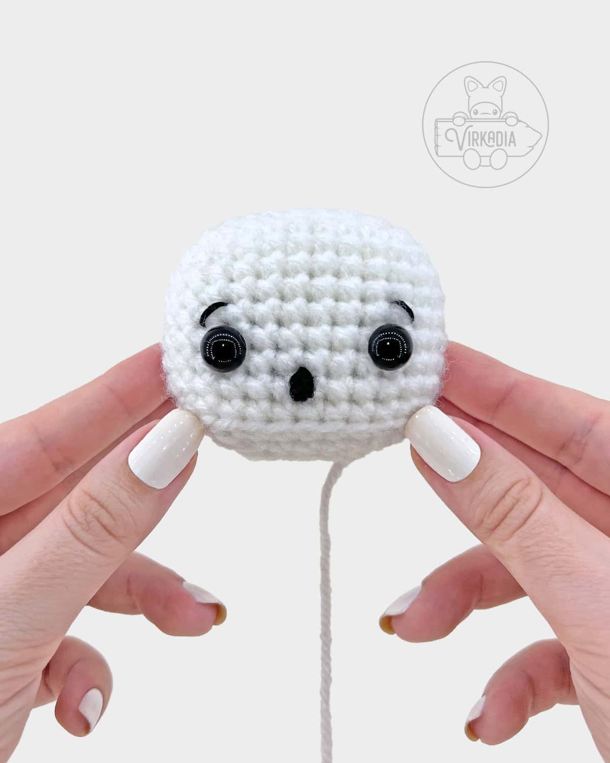 crochet sheet ghost amigurumi pattern tutorial of how the finished face should look after embroidering mouth and eyebrows