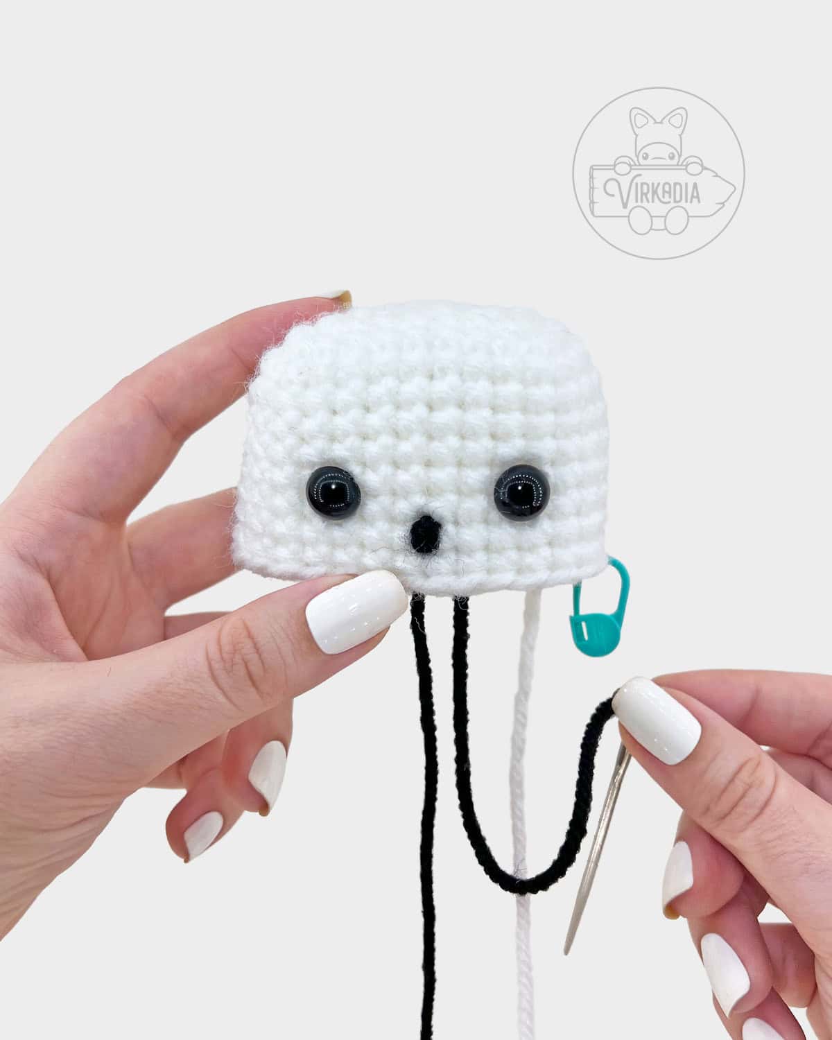 crochet sheet ghost amigurumi pattern tutorial of how to embroider the mouth onto the face