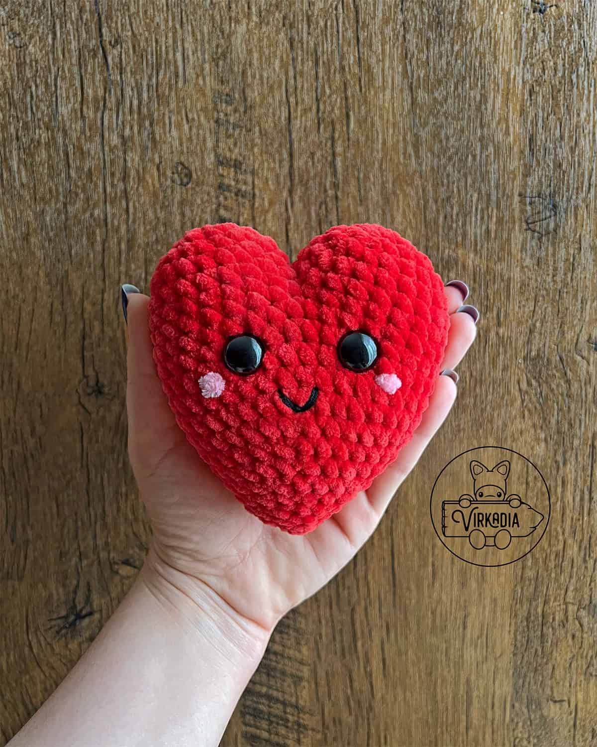 candid shot of crochet heart amigurumi plushie in chunky yarn for Valentine's Day decorations, DIY holiday decor, and handmade romantic gifts