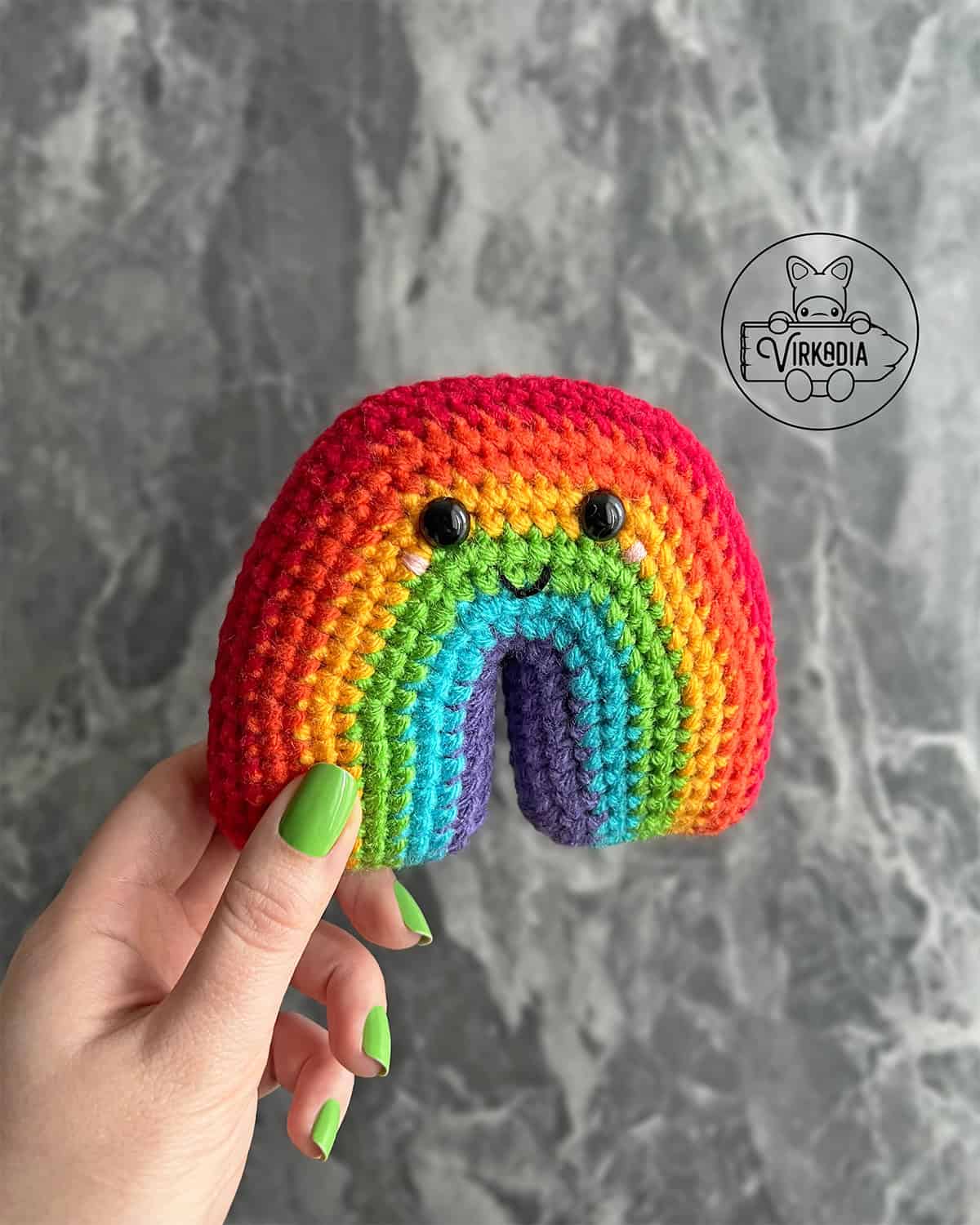 candid shot of crochet rainbow amigurumi plushie for St. Patrick's Day decorations, spring crafts, DIY Pride Month decor, and handmade gifts