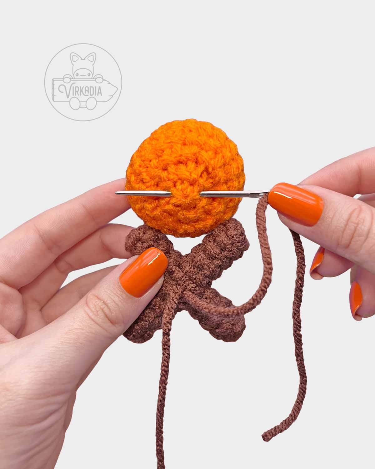 free crochet campfire keychain tutorial of how to sew the logs and flame together